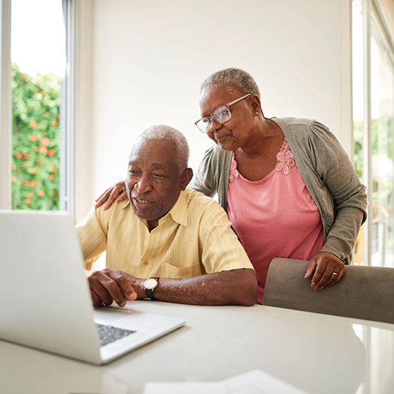 A couple looking at planned giving options on their computer. Links to Beneficiary Designations designations.jpg