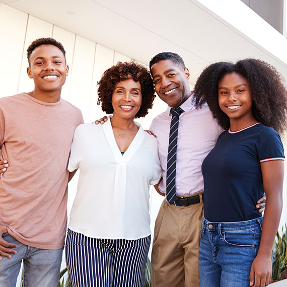 A family of four smiling. Links to Gifts of Real Estate real.jpg